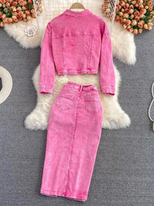 Pink denim jacket and pants on a white fur surface with a blurred background