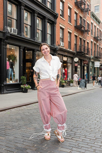 Person wearing pink pants with lace trim in a casual setting